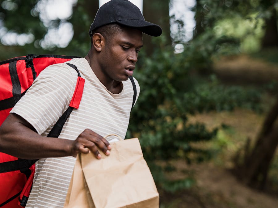 A courier carrying a delivery parcel to drop off for a customer